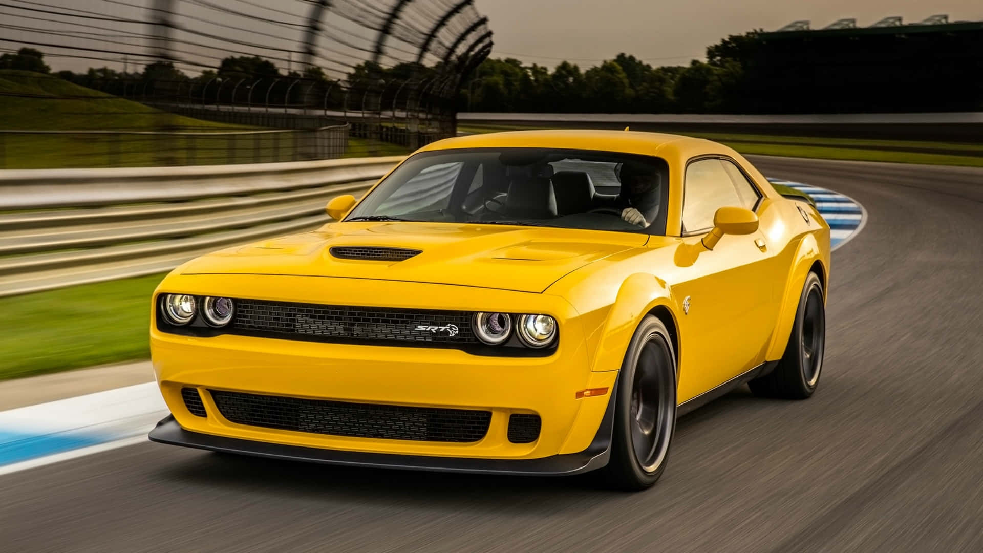The Yellow Dodge Challenger Is Driving On A Race Track