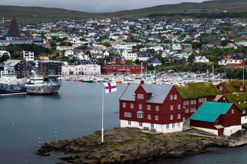 Thorshavn Boats, Houses, And Flag Background