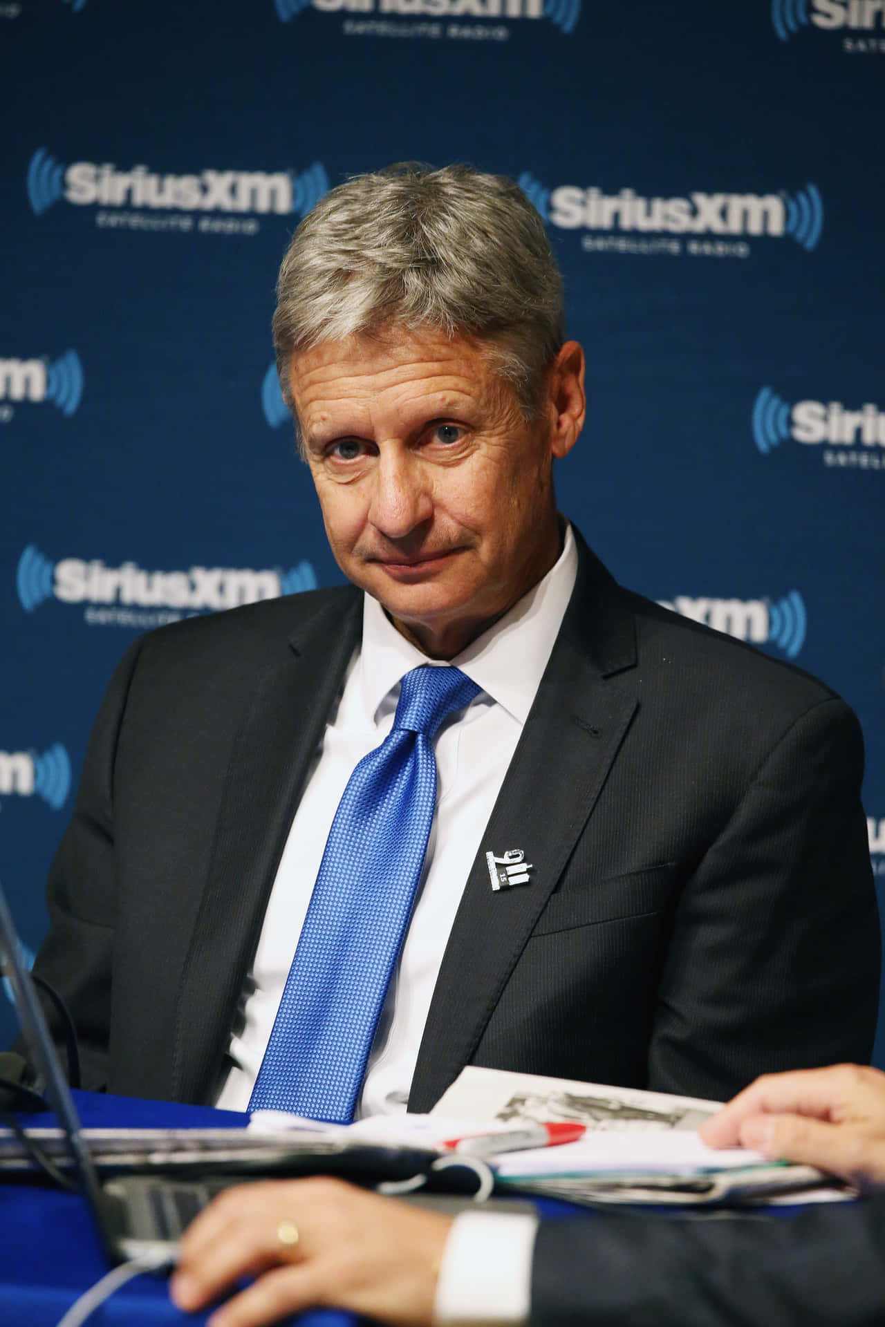 Thoughtful Gary Johnson Against Blue Backdrop Background