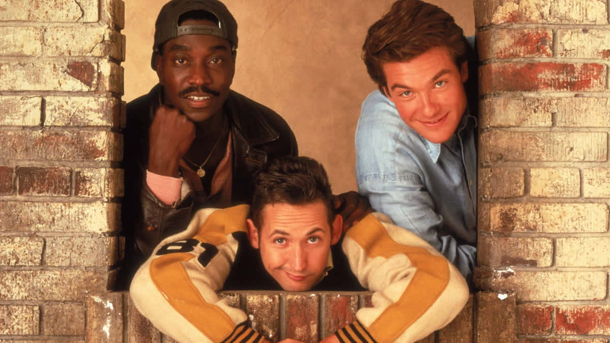 Three_ Comedians_ Brick_ Wall_ Backdrop Background