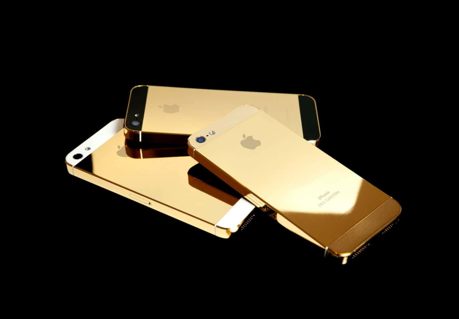 Three Gold Iphones On A Black Background Background