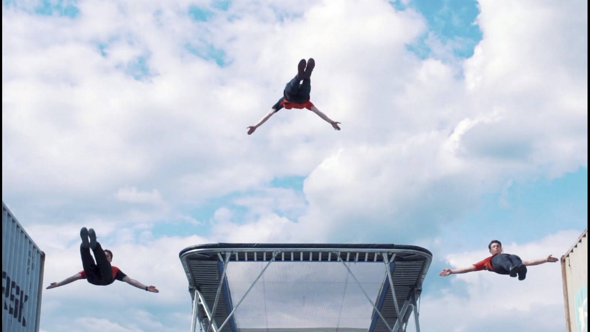 Three Guys High Jumping From A Trampoline