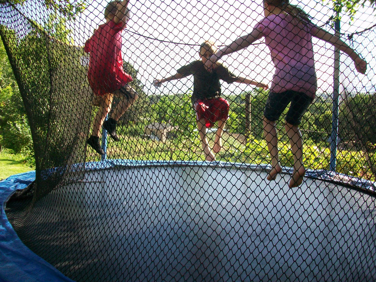 Three Kids Jumping On A Trampoline Background