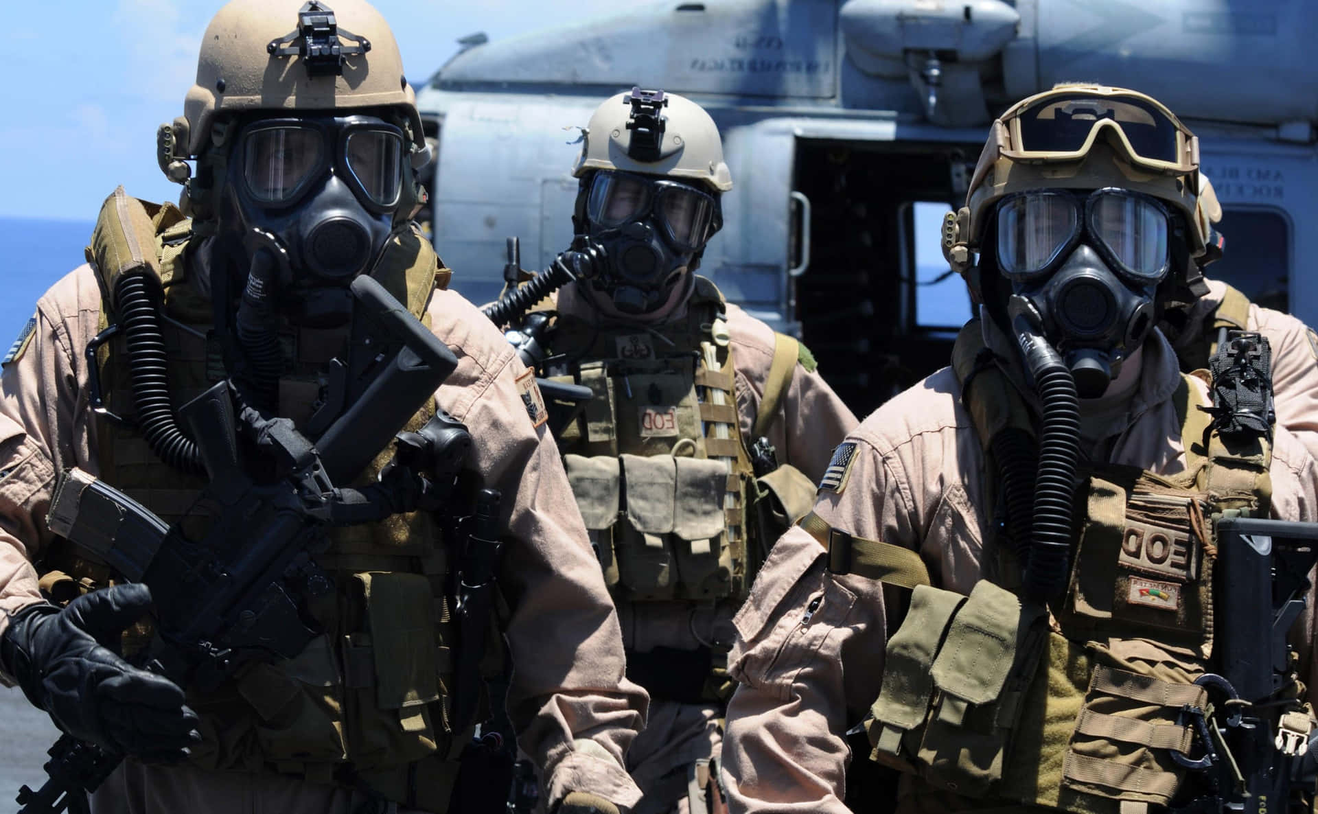 Three Marines In Gas Masks On A Helicopter Background