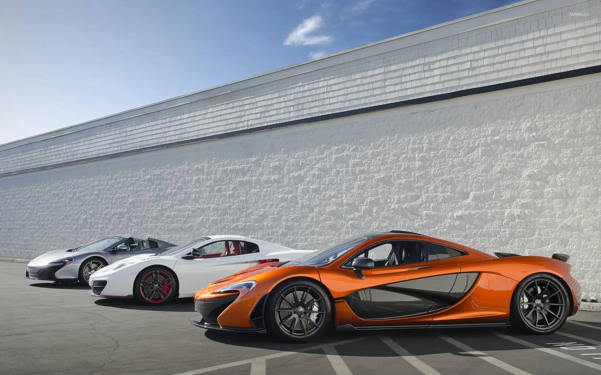 Three Mclaren Spyder Vehicles Parked Background