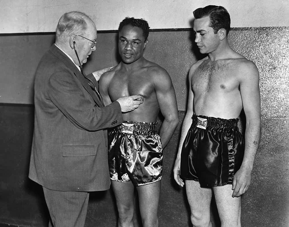 Three Men In Boxing Shorts Standing Next To Each Other Background