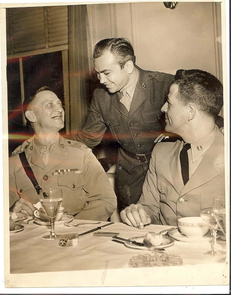 Three Men In Uniforms Sitting At A Table Background