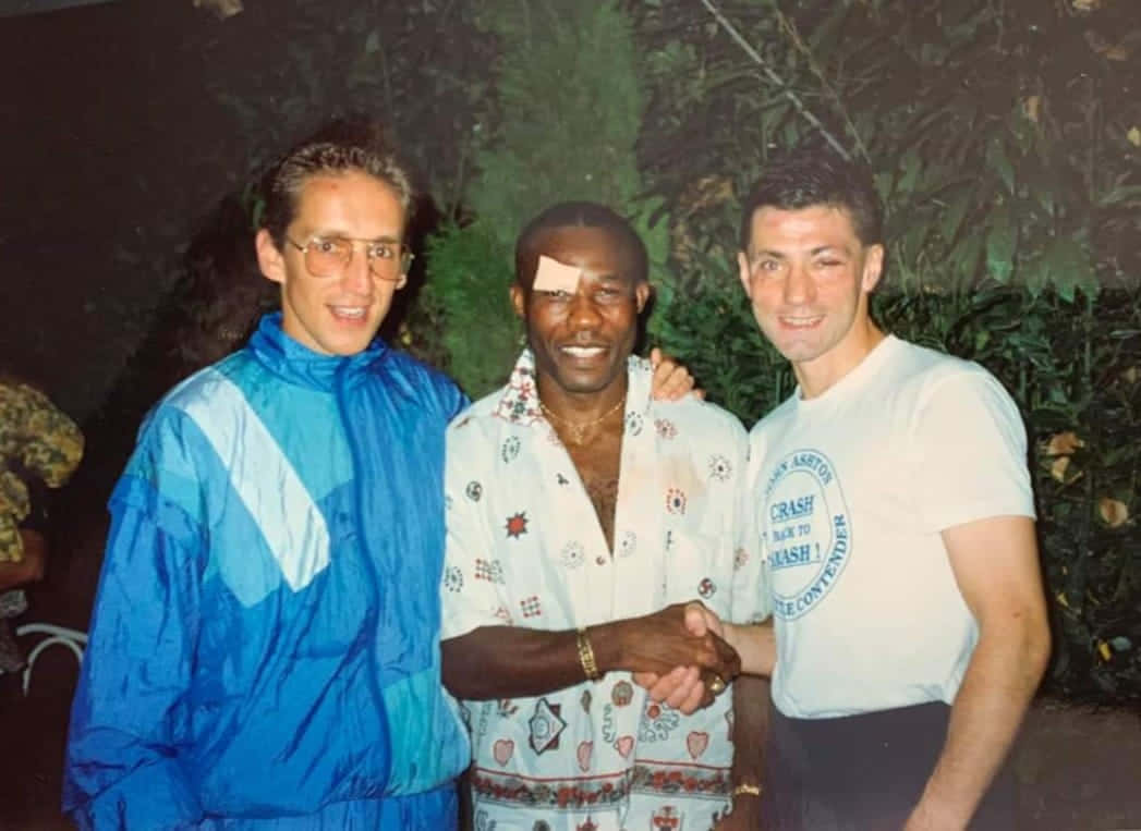 Three Men Shaking Hands Outdoors Background