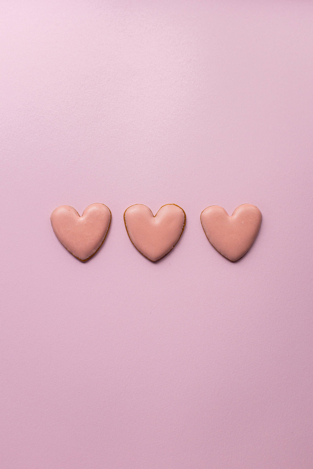 Three Pastel Pink Heart Sugar Cookies Background