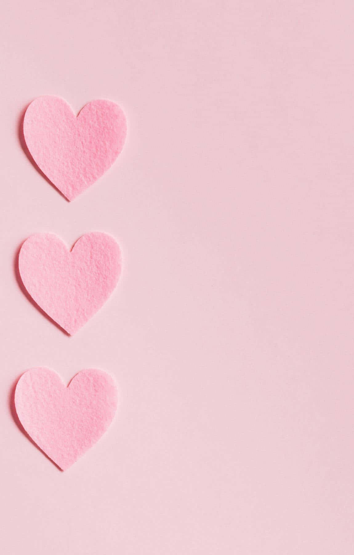 Three Pink Heart Shaped Paper On A Pink Background Background