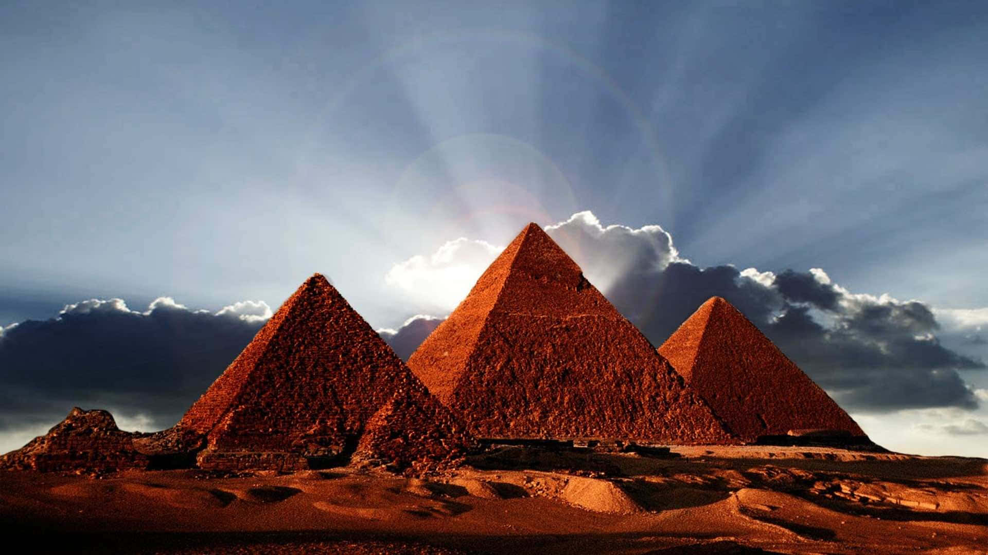 Three Pyramids In The Desert With Sun Shining On Them