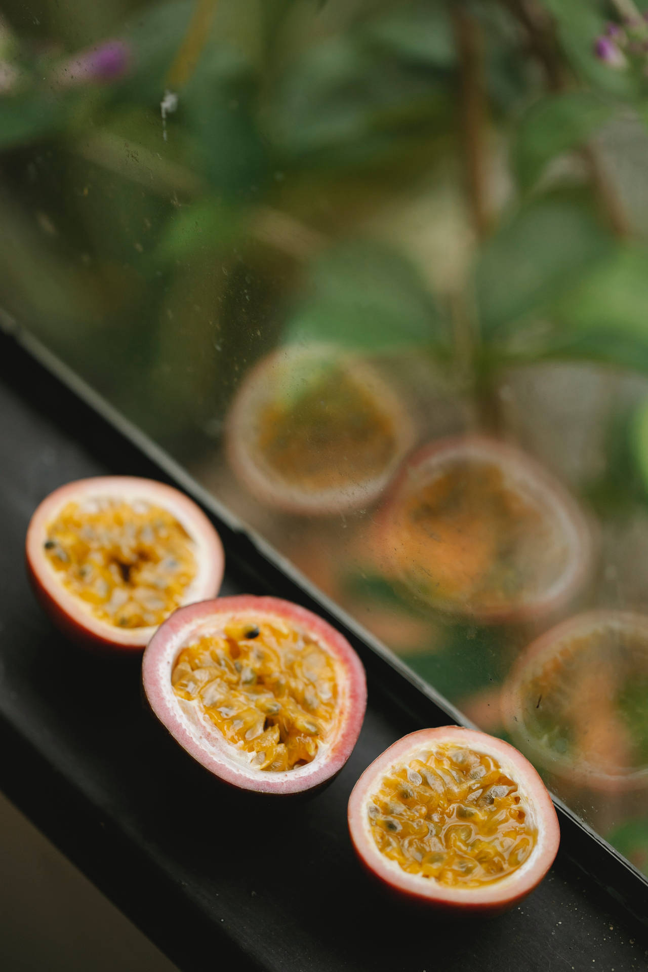 Three Sliced Passion Fruit By The Window Background