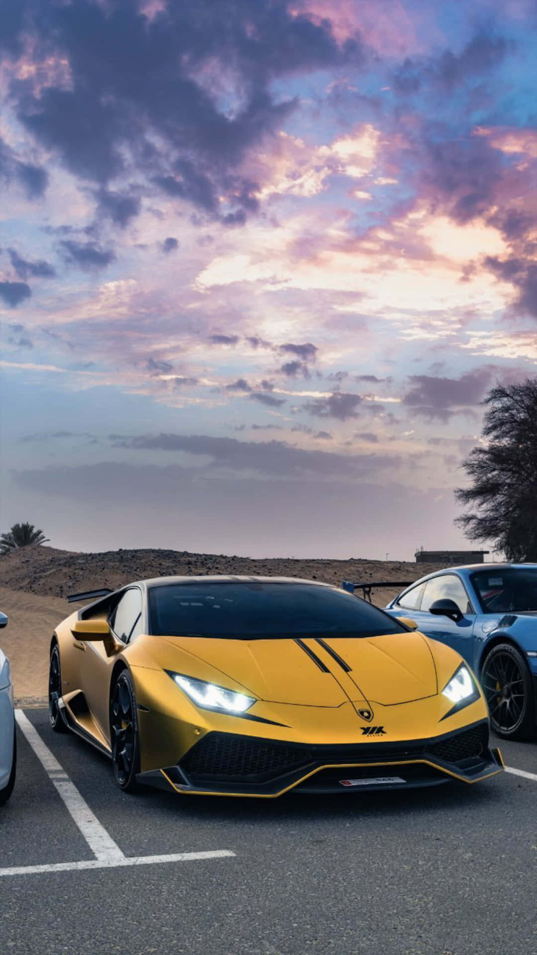 Three Sports Cars Parked In A Parking Lot Background
