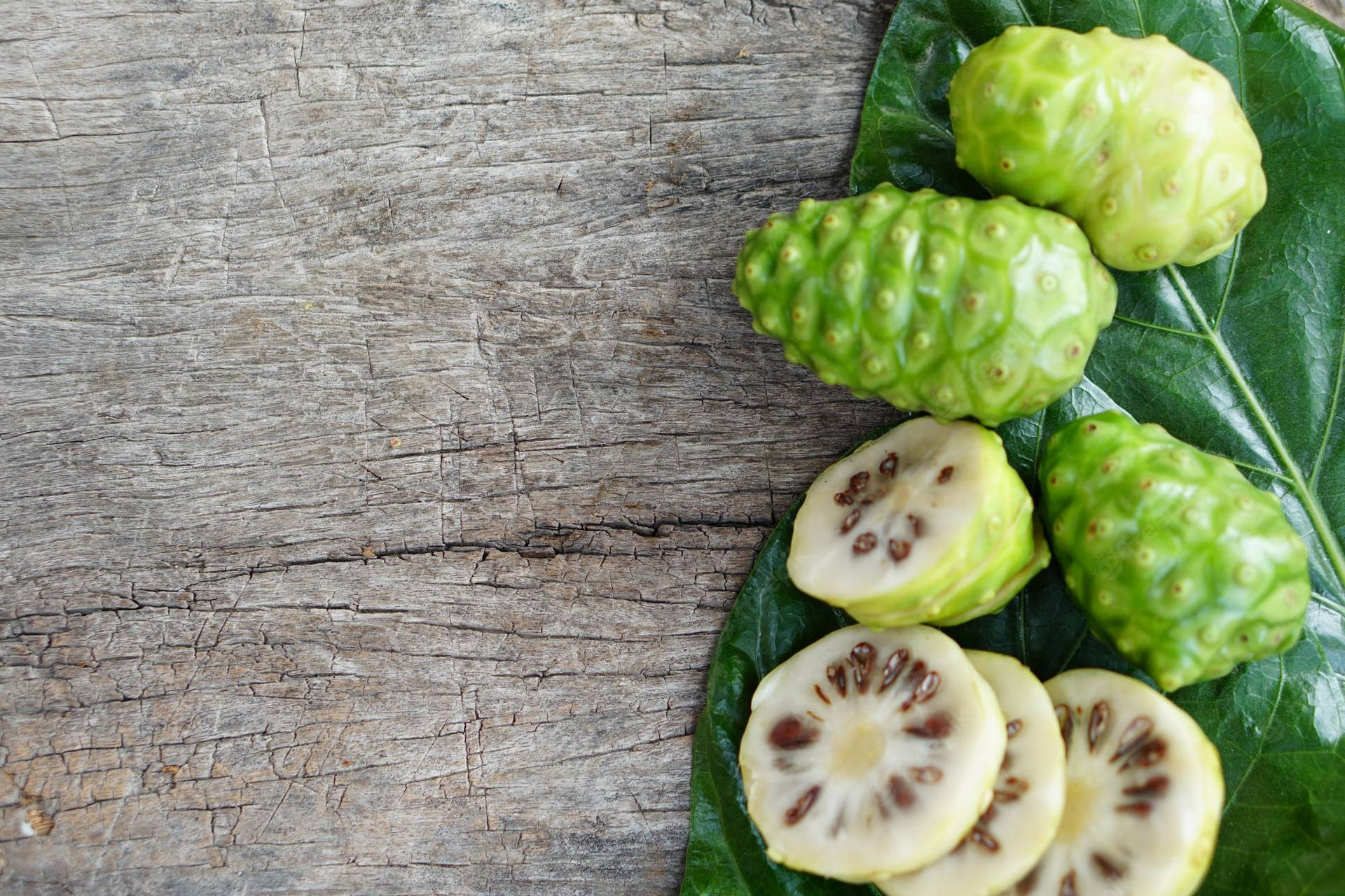 Three Whole Noni Fruits And Slices Background