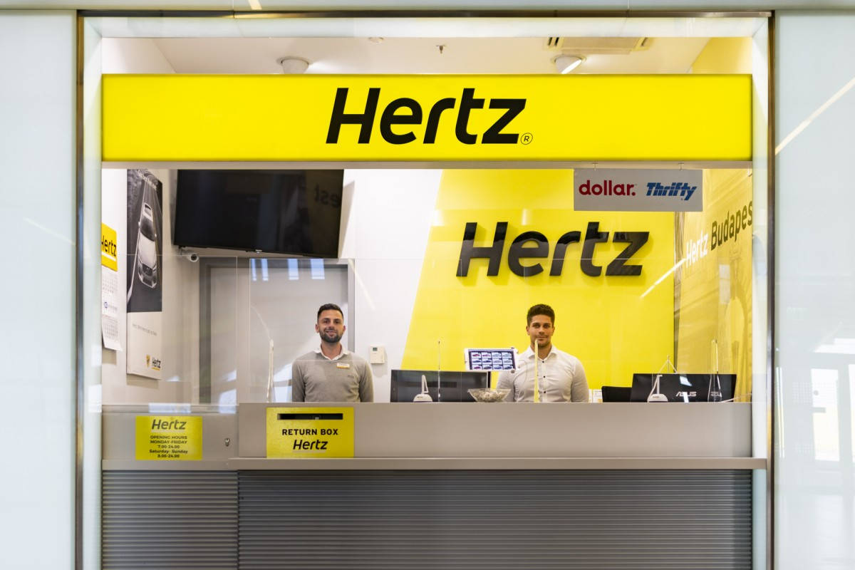 Thrifty Logo At Hertz Car Rental Background