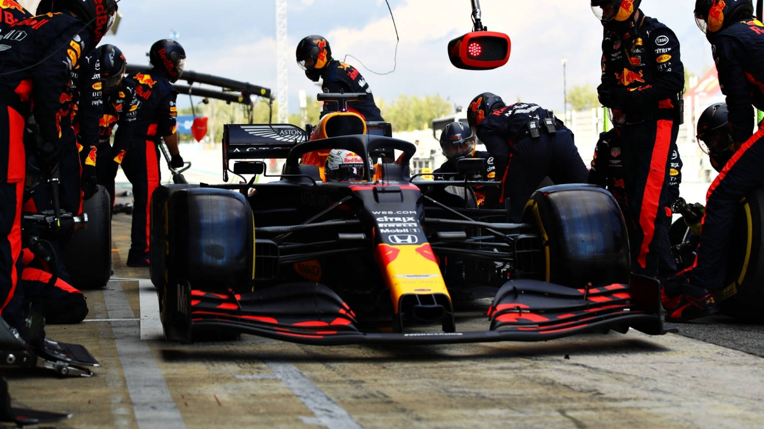 Thrilling Action At The Red Bull Racing Pit Stop Background