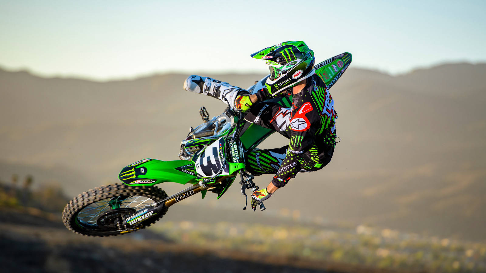 Thrilling Action With A Monster Dirt Bike Background