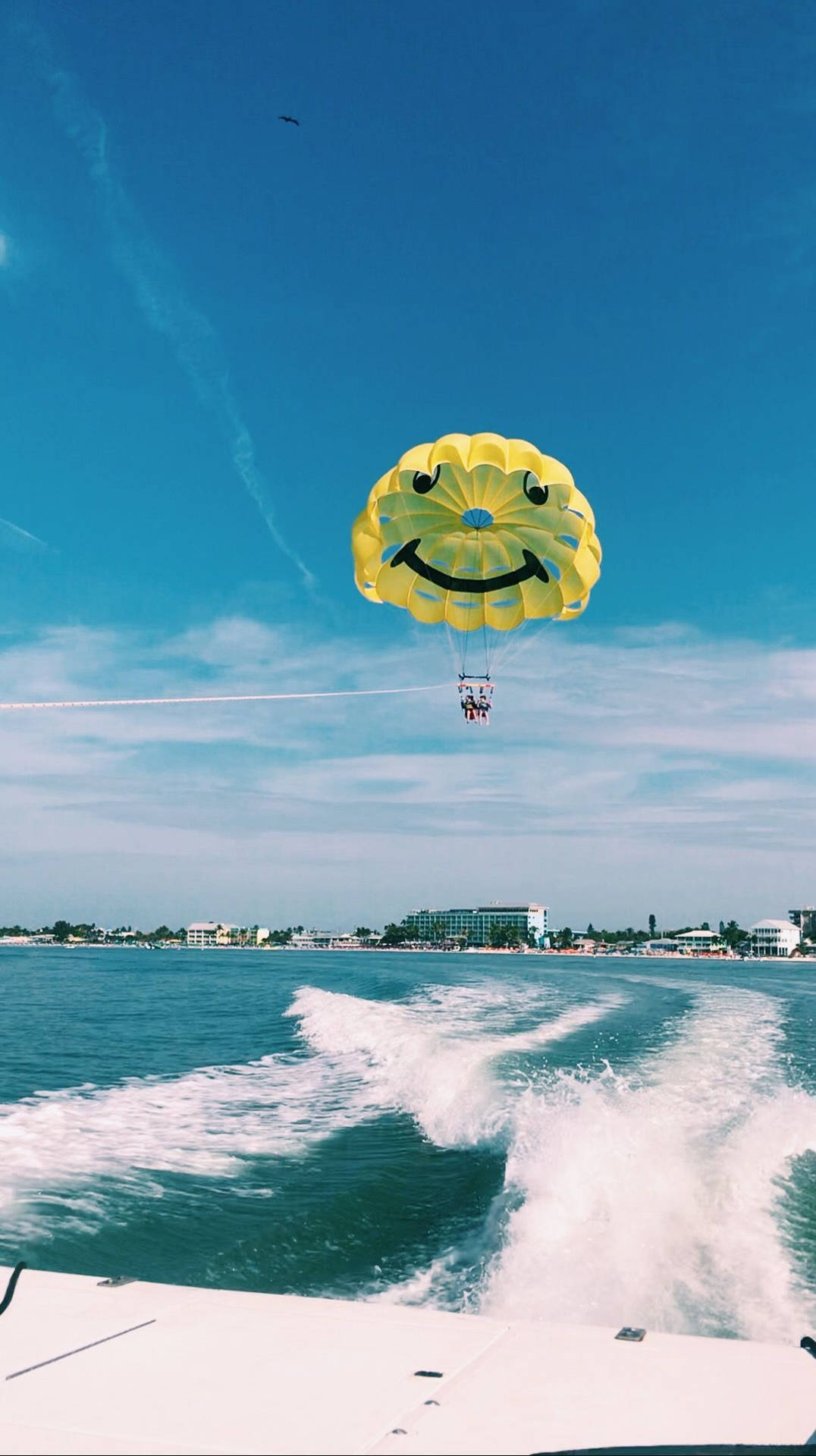 Thrilling Adventure At Sea - Parasailing Behind Speed Boat Background