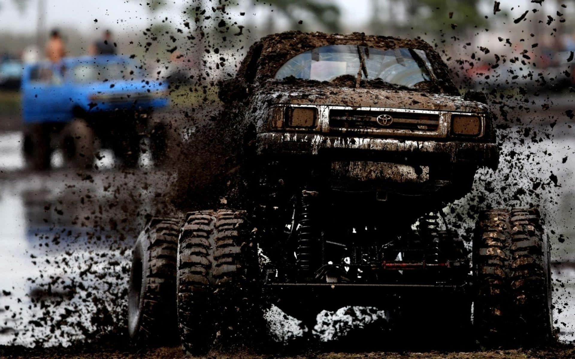 Thrilling Adventure With A Monster Truck Plowing Through The Mud Background