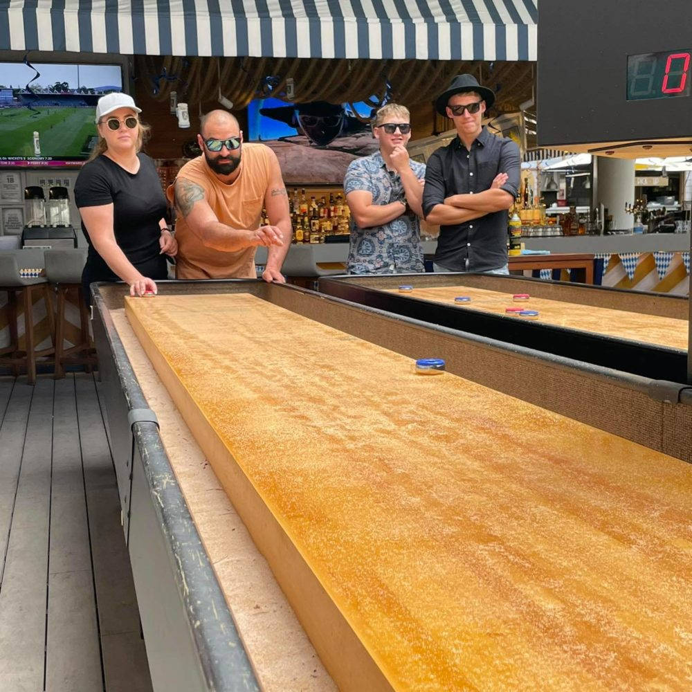 Thrilling Competition On Shuffleboard Table Background