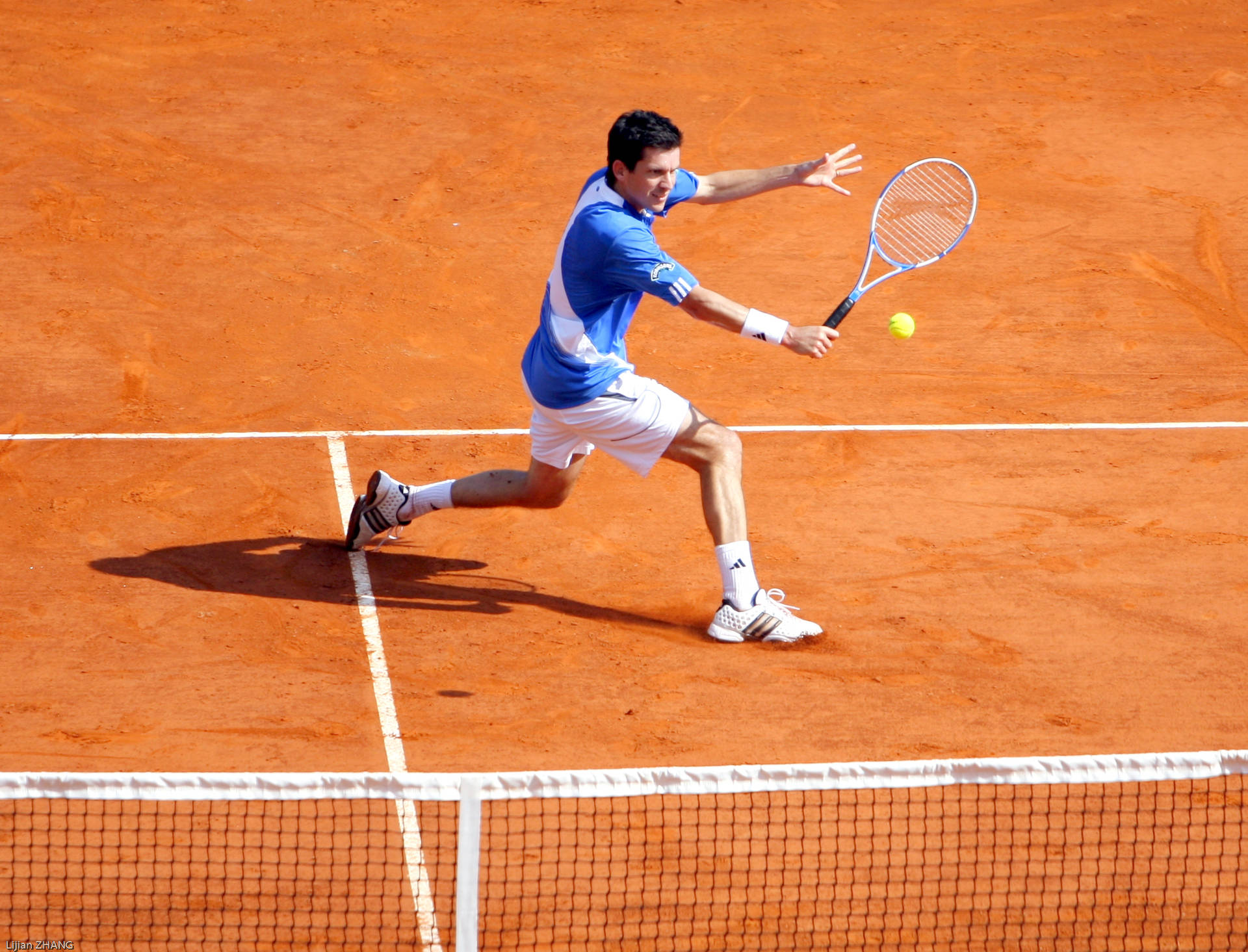 Tim Henman Fiercely Competing On A Clay Court Background