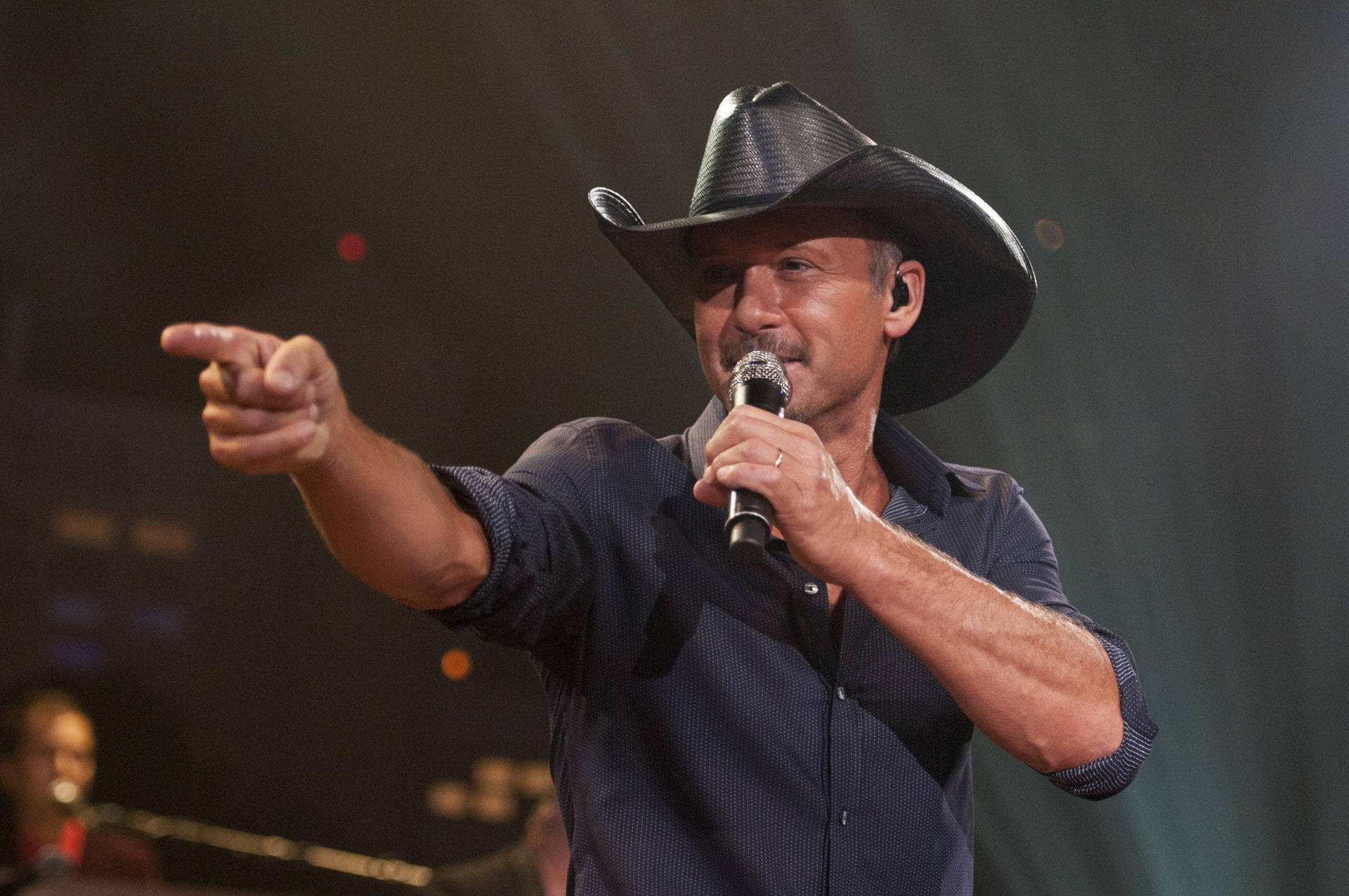 Tim Mcgraw Pointing On Stage Background