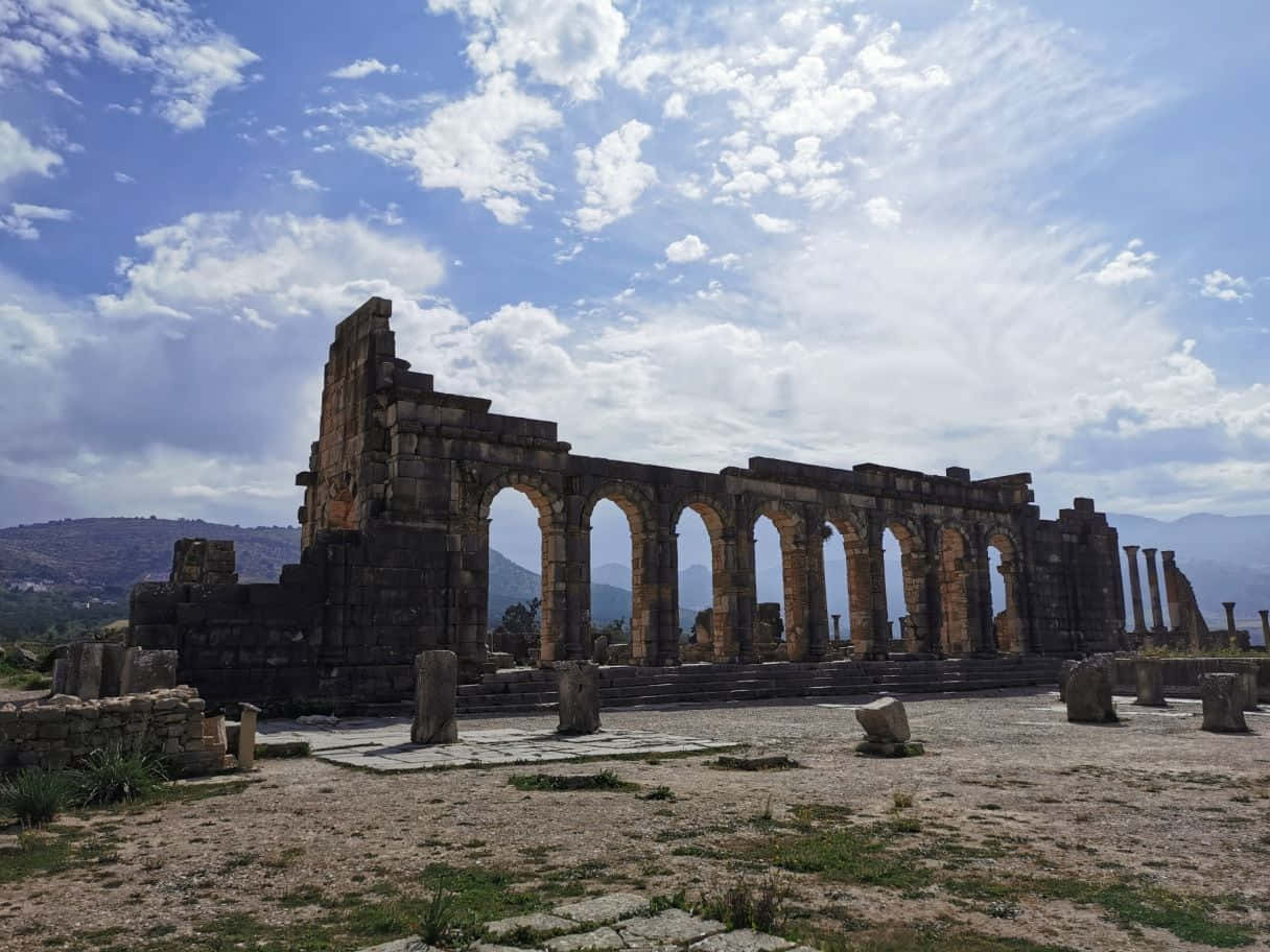 Timeless Remains Of Volubilis Arch Ruins Background