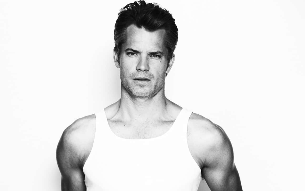 Timothy Olyphant Striking A Pose In A Stylish Outfit Background