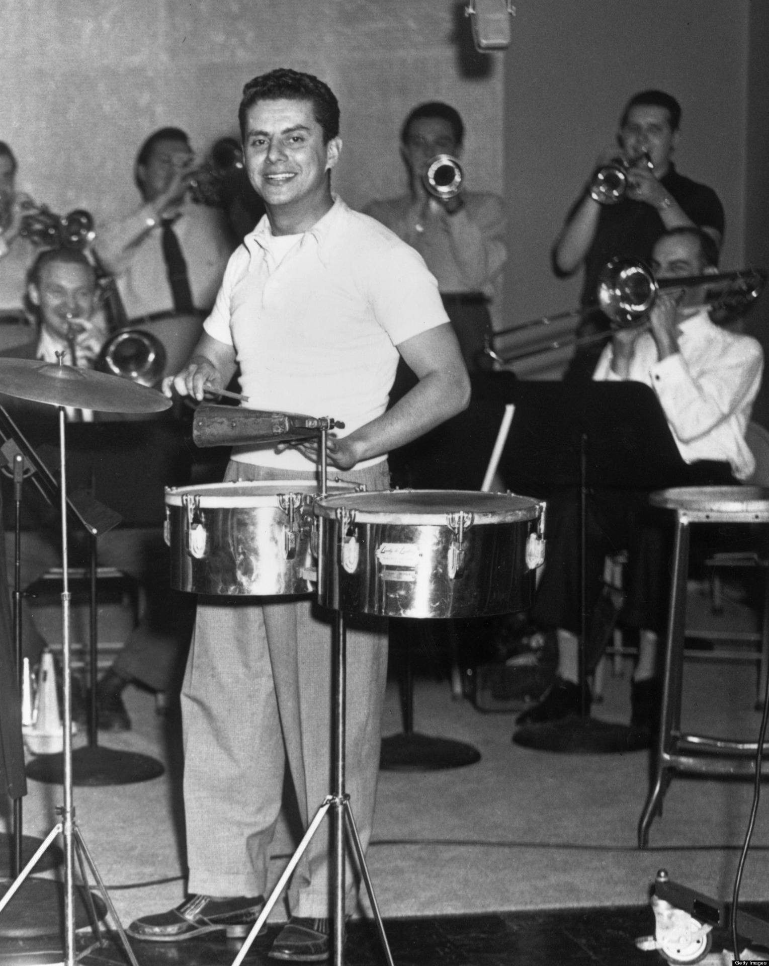 Tito Puente Leading His Vibrant Band In A Live Performance. Background