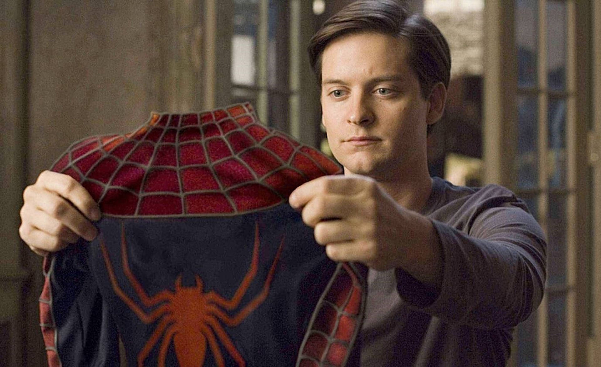 Tobey Maguire Holding Spider Man Suit Background