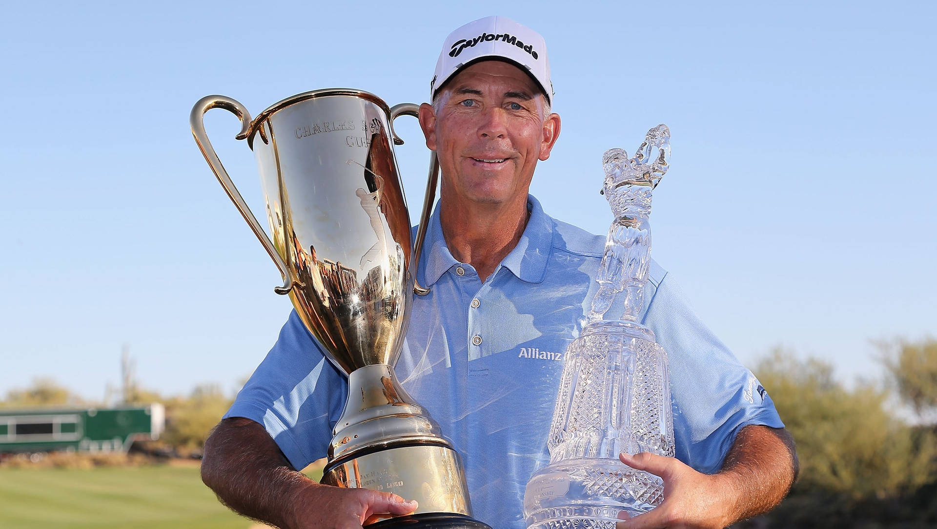 Tom Lehman Celebrating Victory With Two Trophies Background