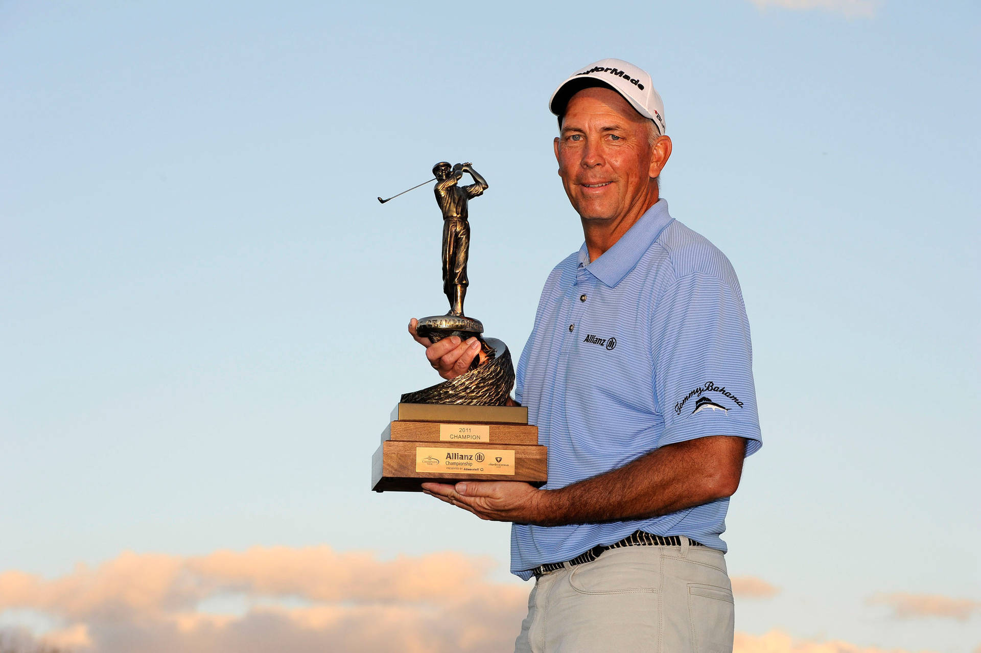 Tom Lehman Holding A Golf Trophy Background