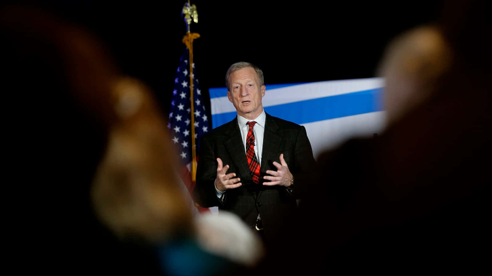 Tom Steyer Beside A Flag Background