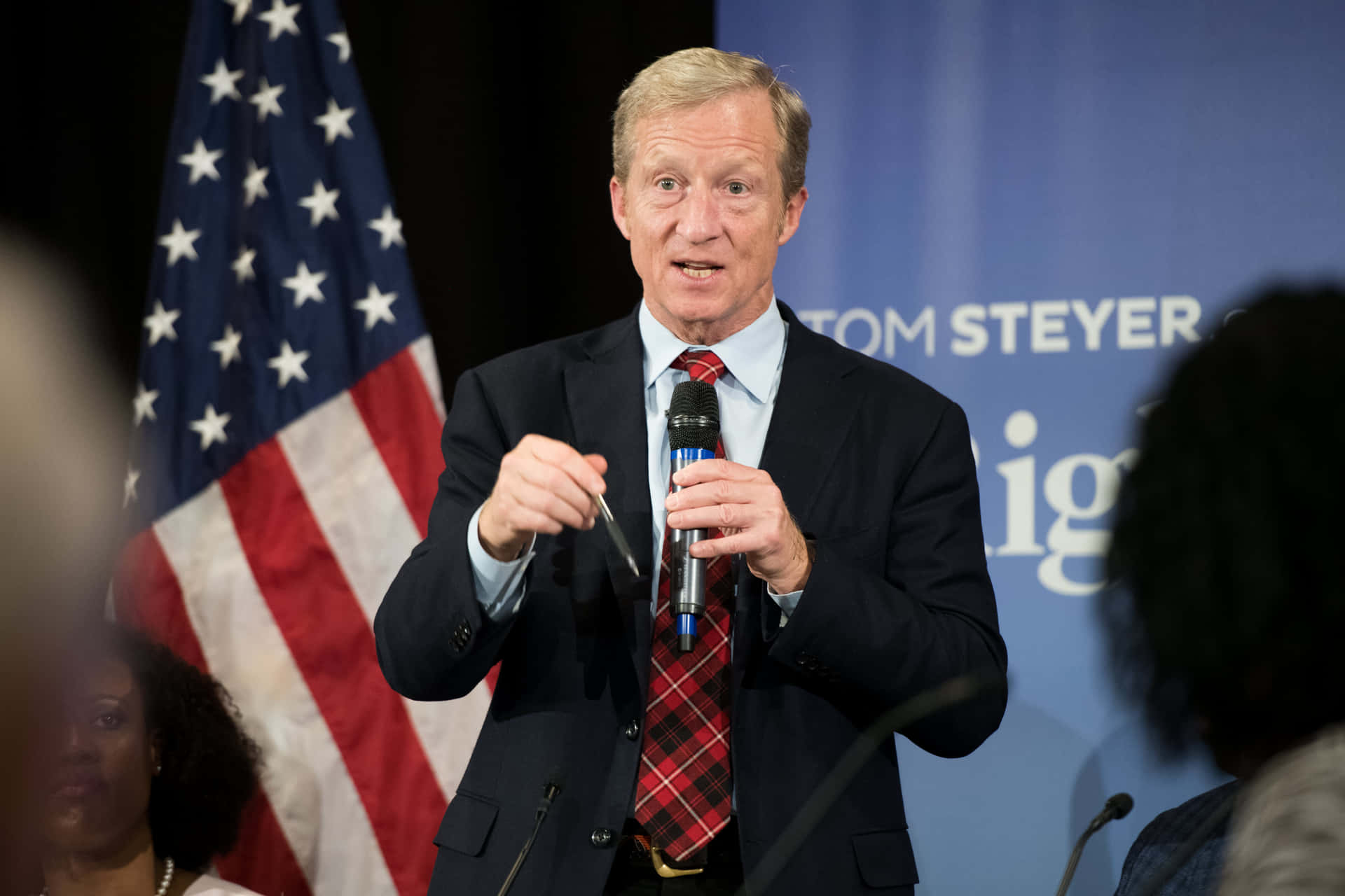 Tom Steyer Holding A Microphone Background