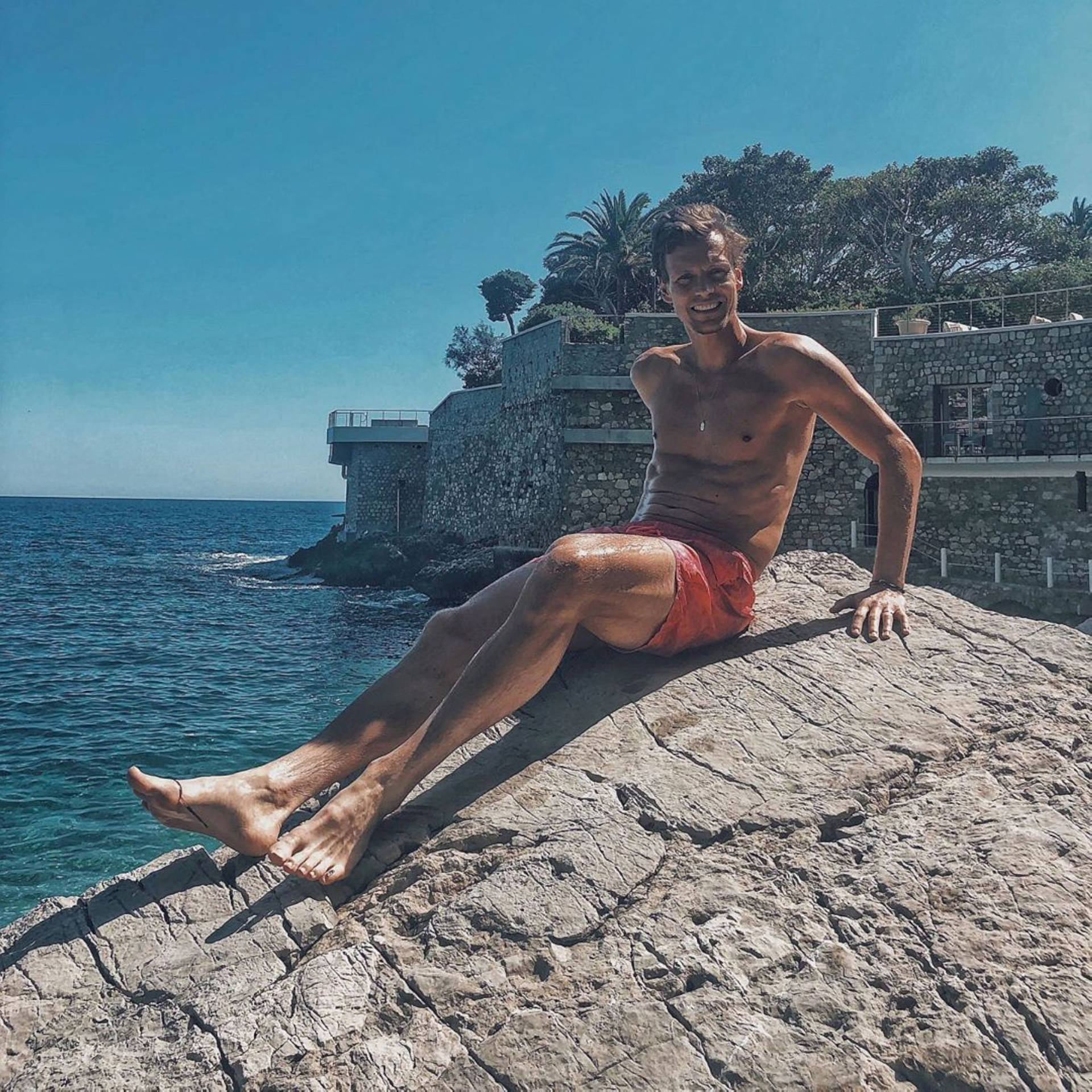 Tomas Berdych Sitting On Rock Background