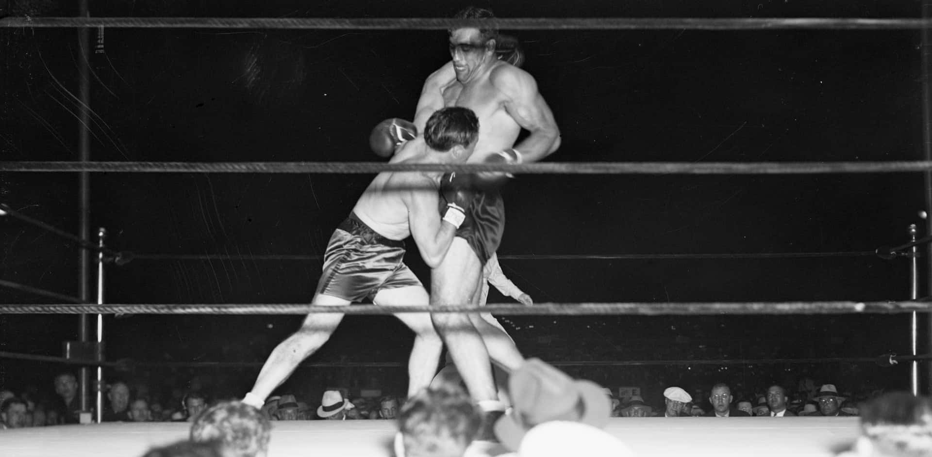 Tommy Loughran Delivering A Punch During A Boxing Match Background