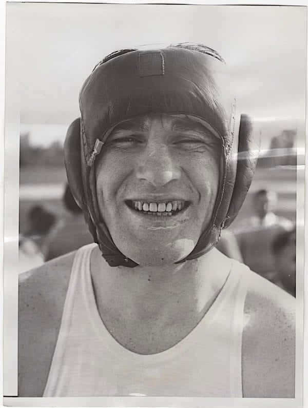 Tommy Loughran Smiling With Protective Headgear Background