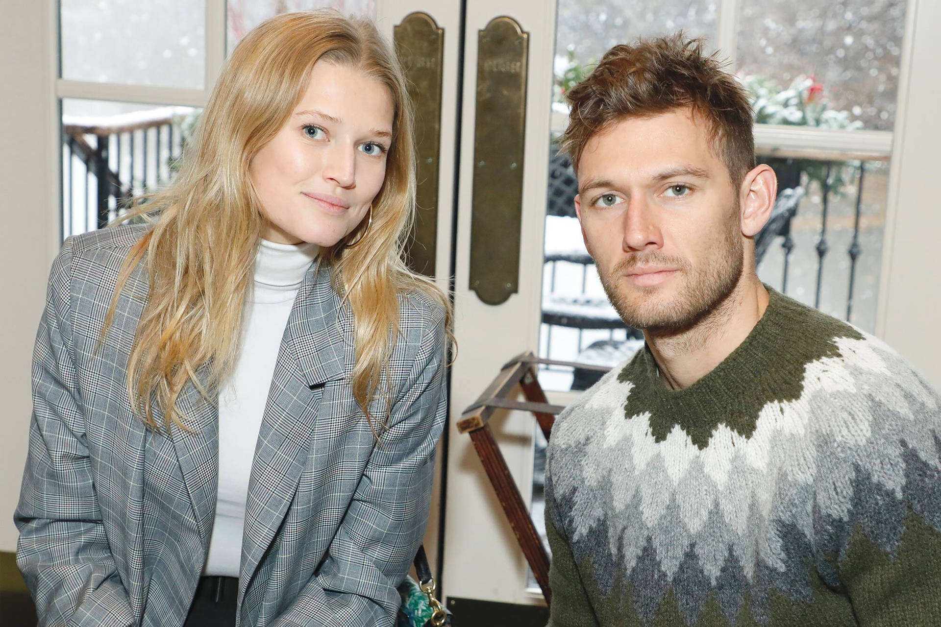 Toni Garrn And Alex Pettyfer Posing Together During An Event Background