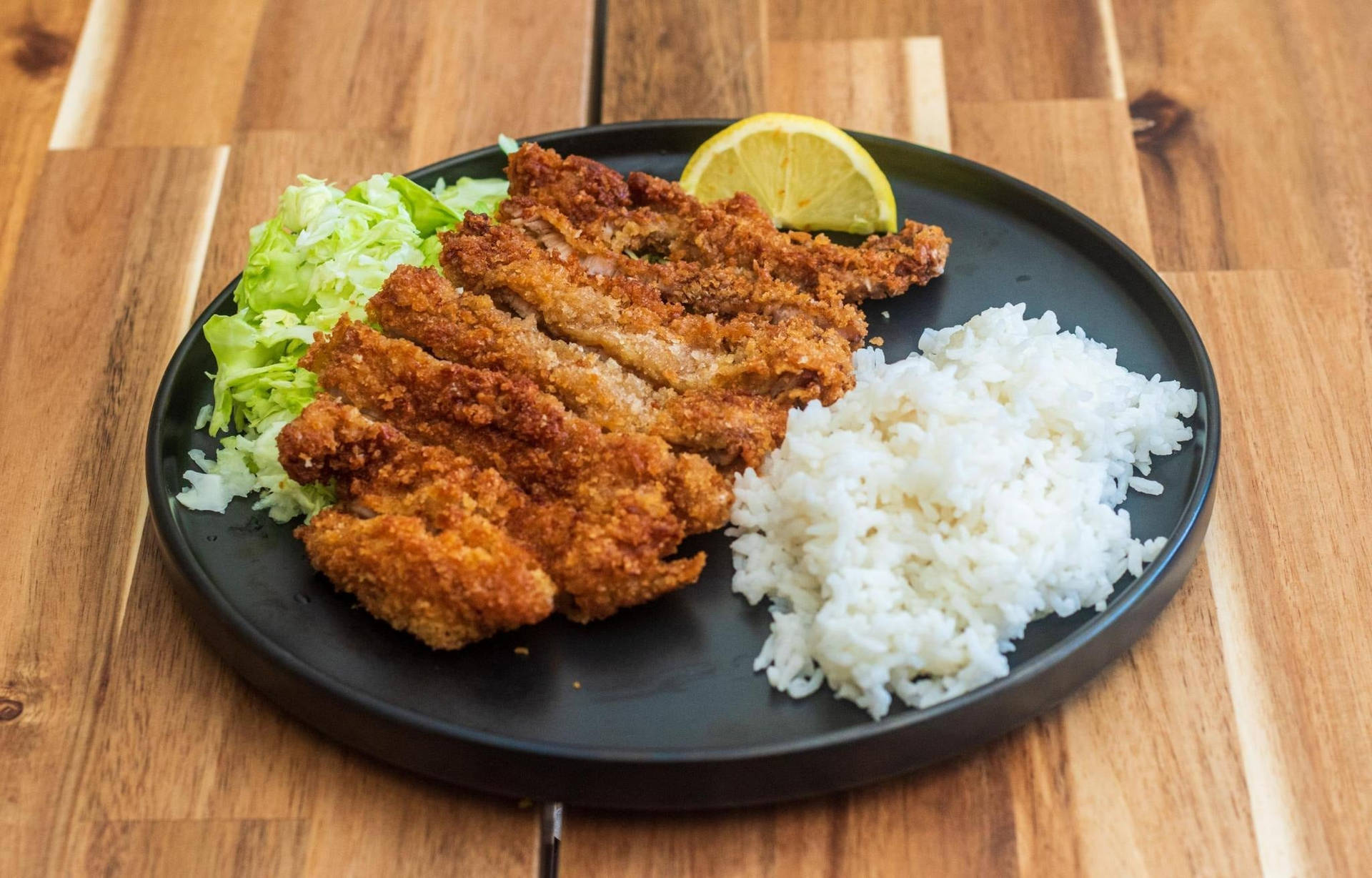 Tonkatsu Served On A Round Plate With Rice Background