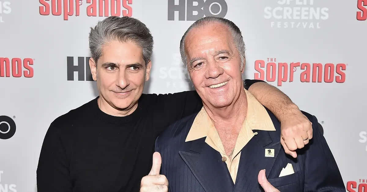 Tony Sirico Smirking In A Suit Background