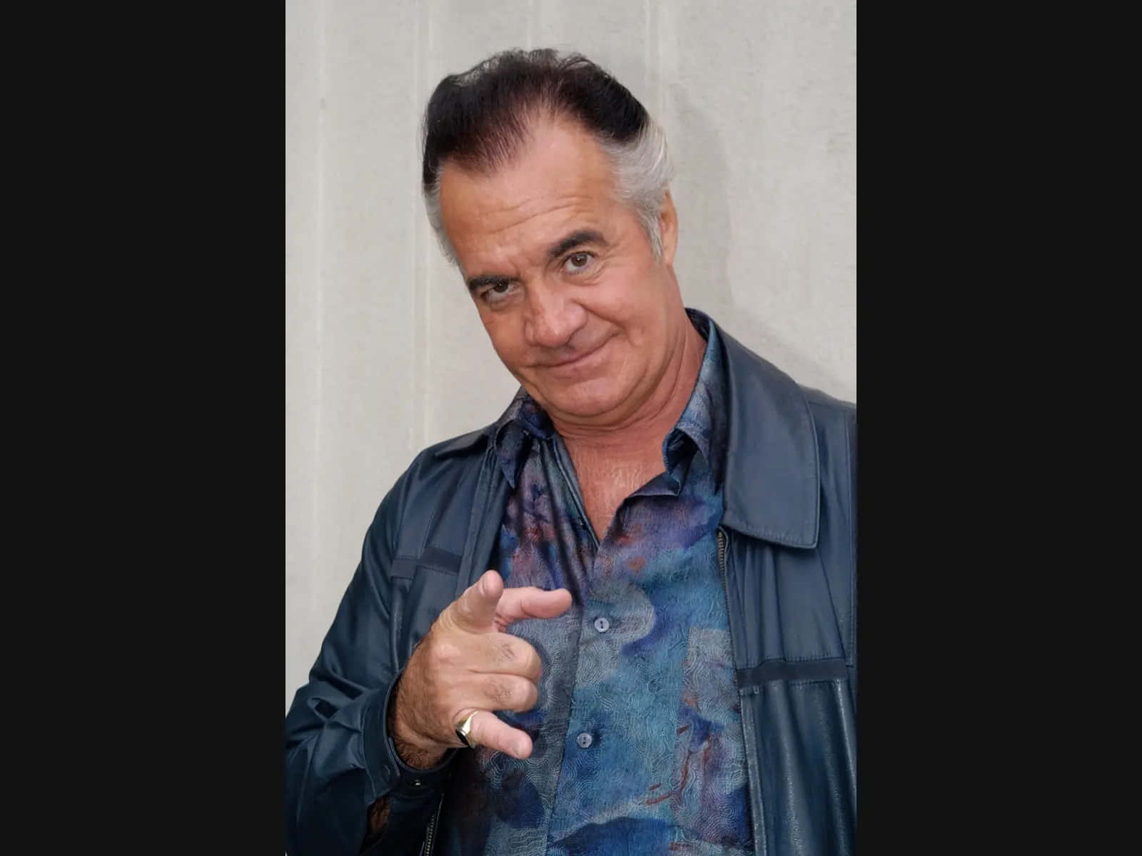 Tony Sirico Striking A Pose In A Stylish Suit Background