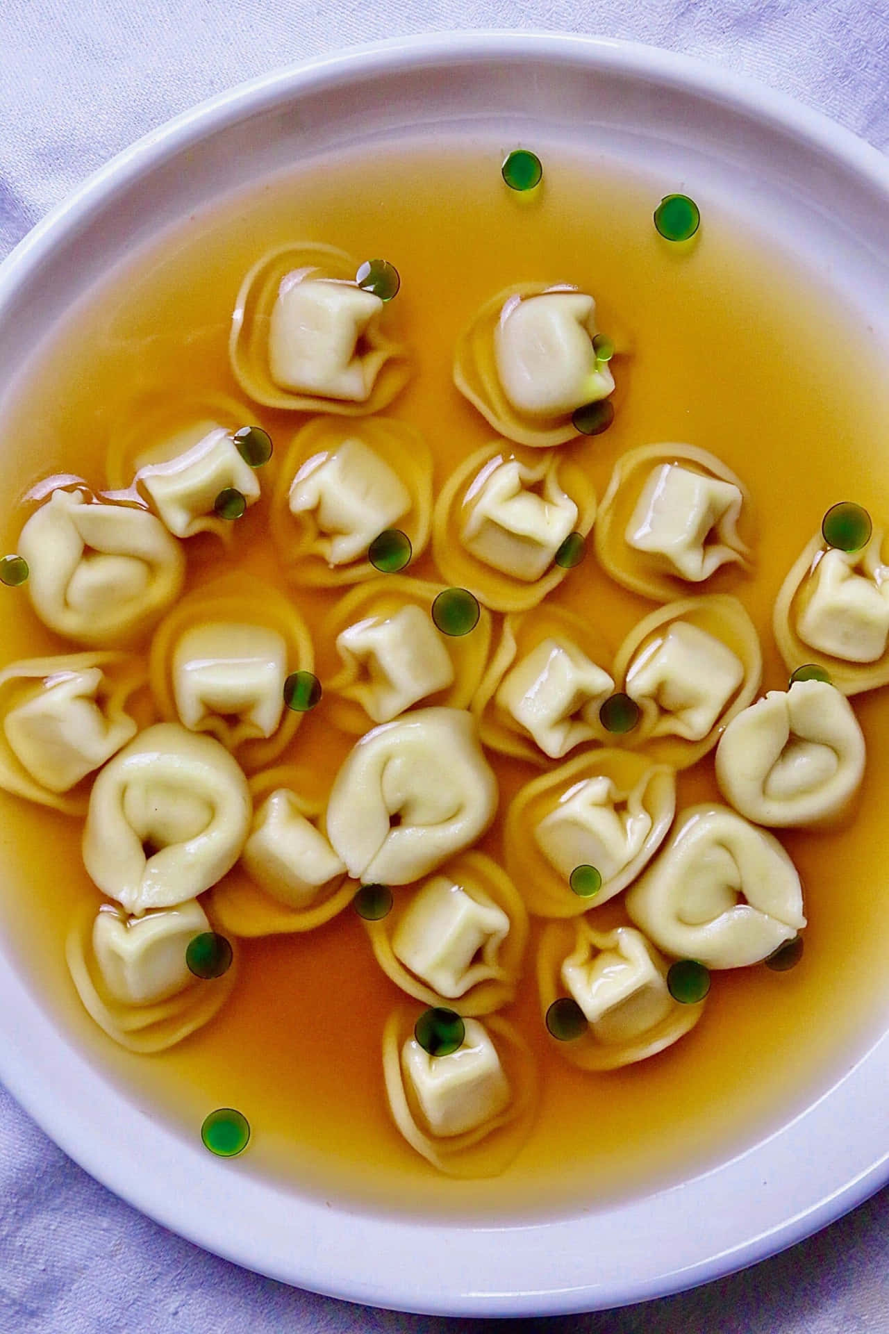 Tortellini In Brodo On A Purple Plate Background