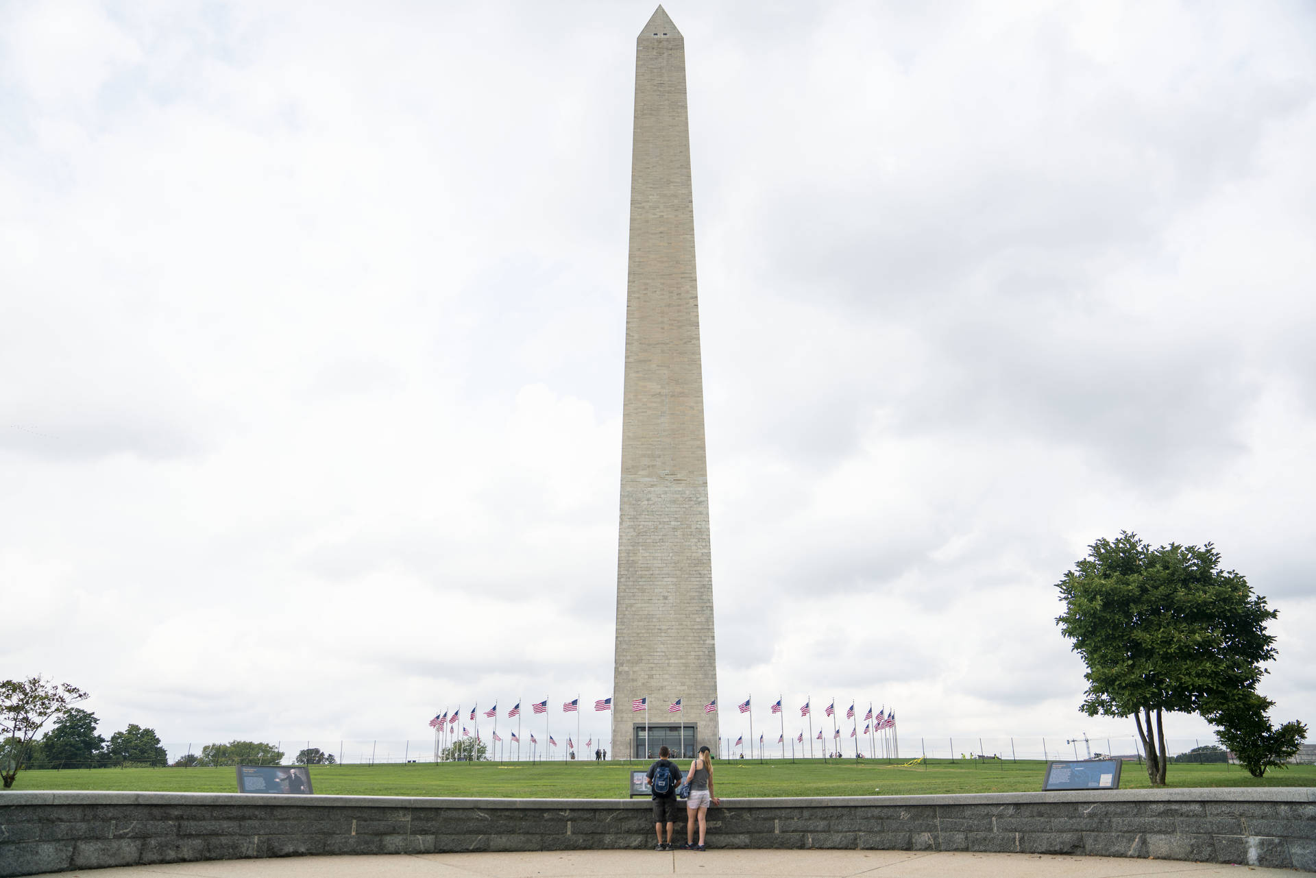 Tourist Pair Watching Washington Monument Background