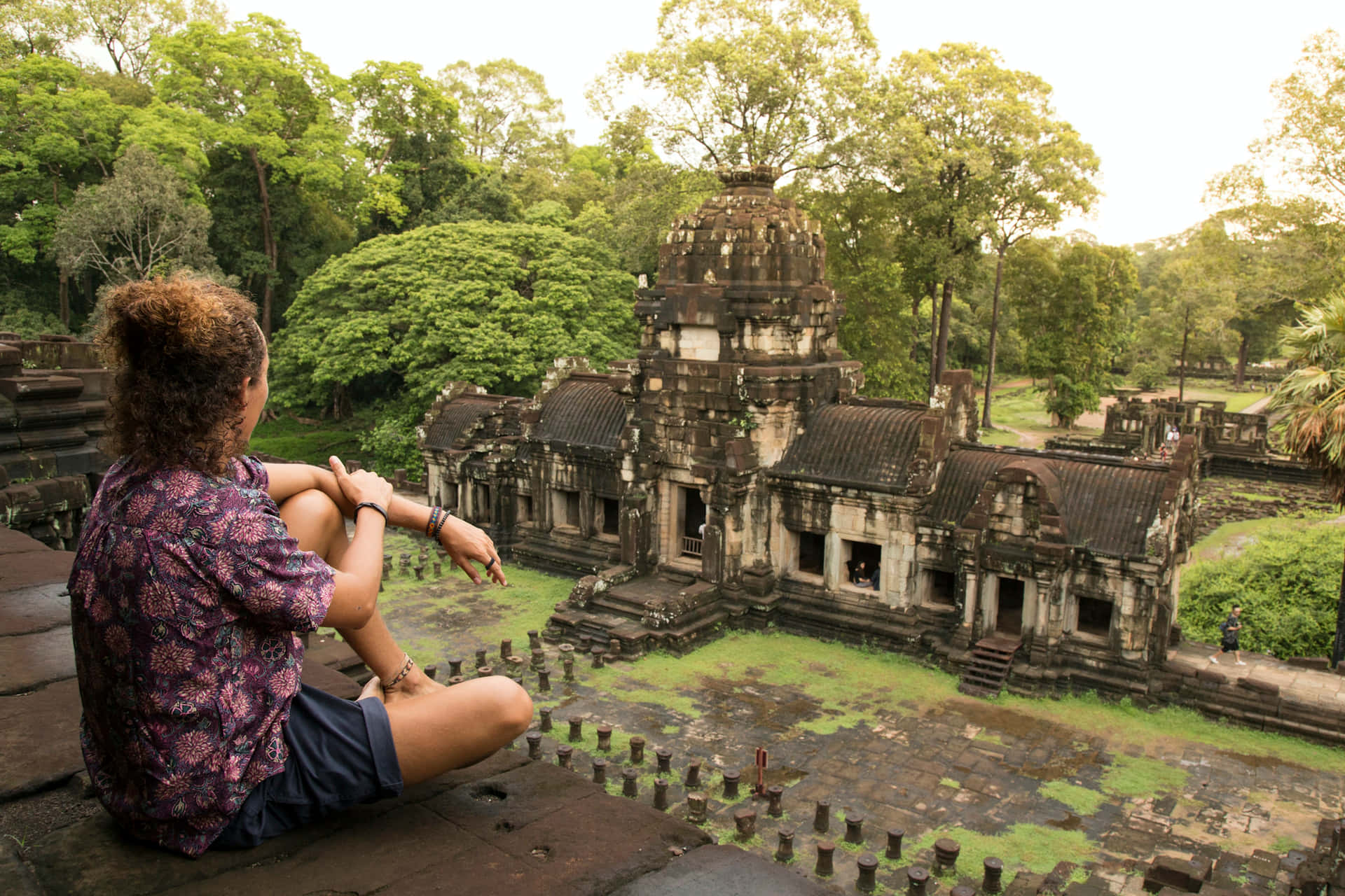 Tourist Sitting Atop Angkor Thom Ruins