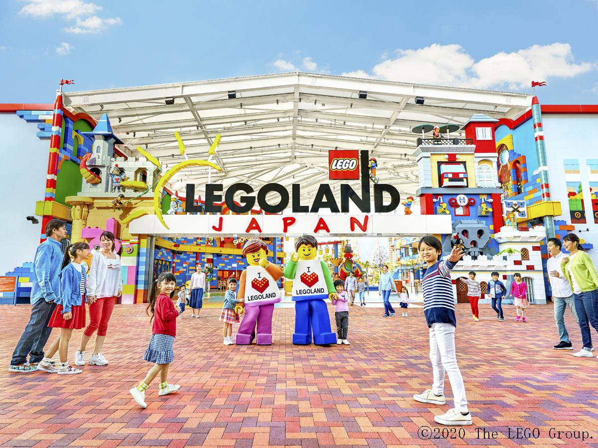 Tourists And Mascots At Legoland Japan Background