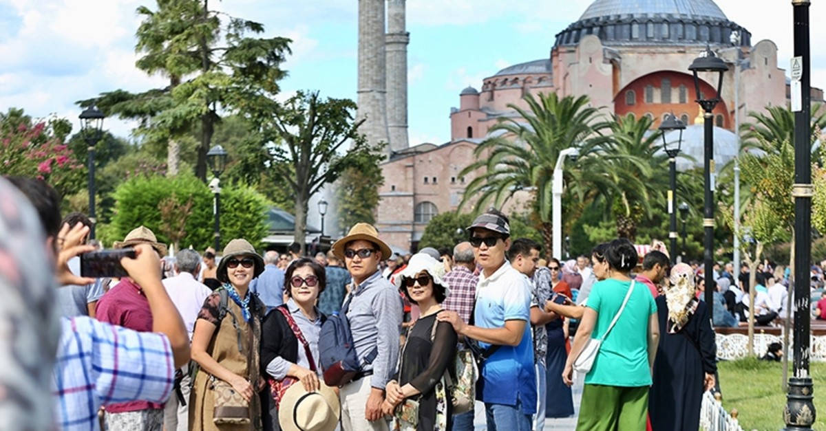 Tourists Exploring The Iconic Hagia Sophia In Istanbul Background
