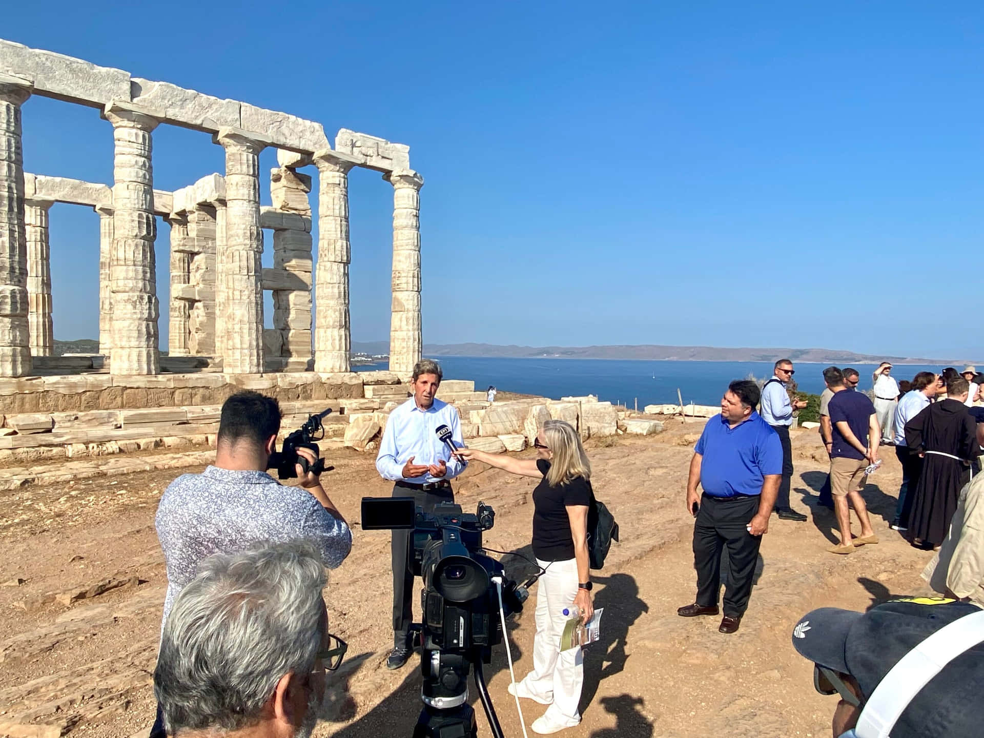 Tourists In Poseidon Temple Sounion Background