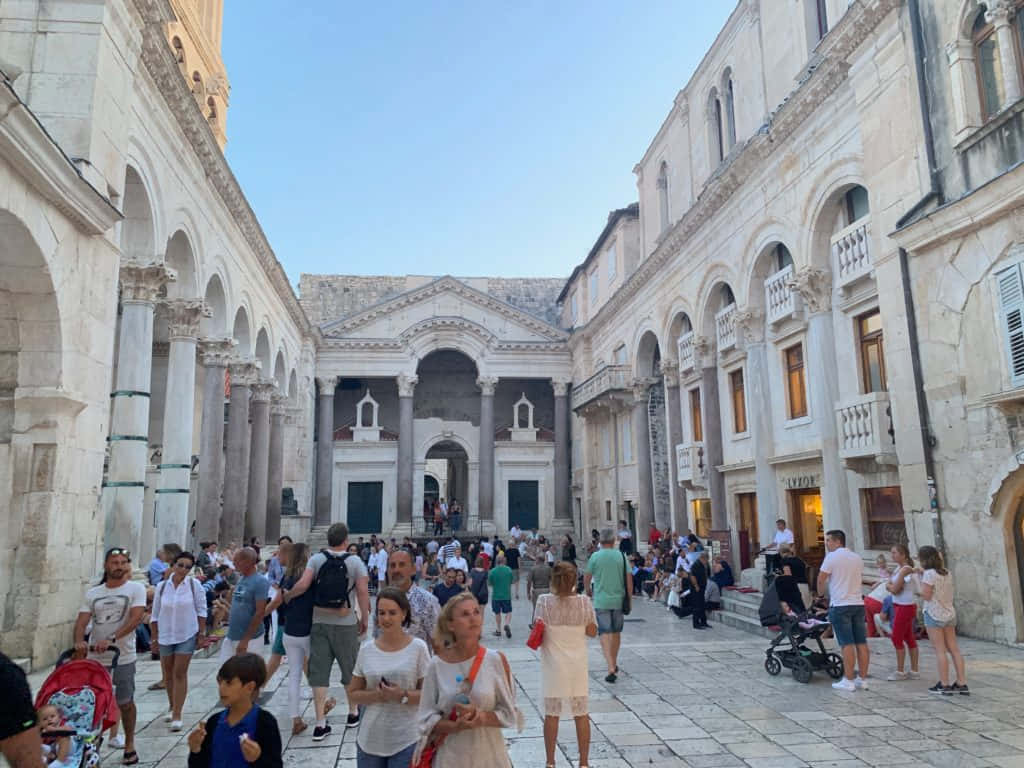 Tourists In The Diocletians Palace Background
