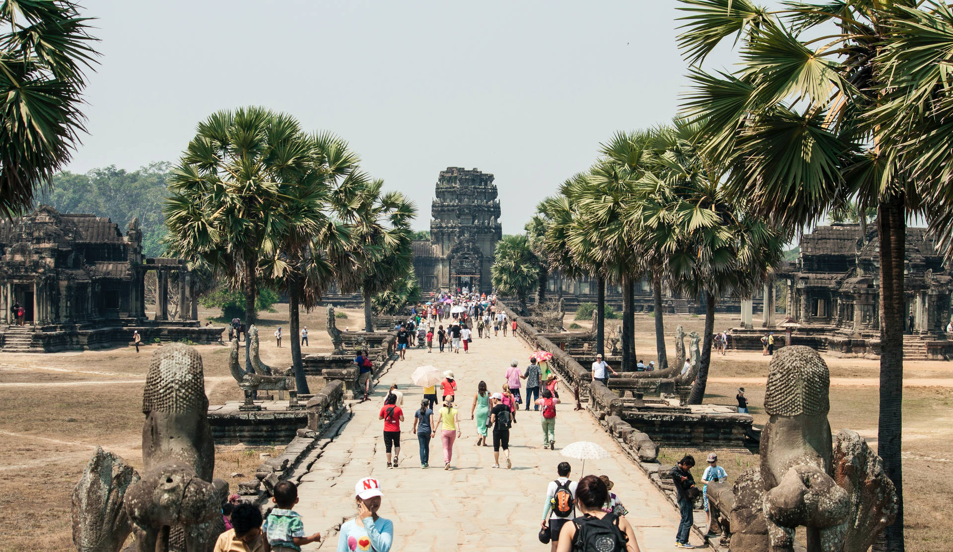 Tourists Walking Towards Angkor Wat Background