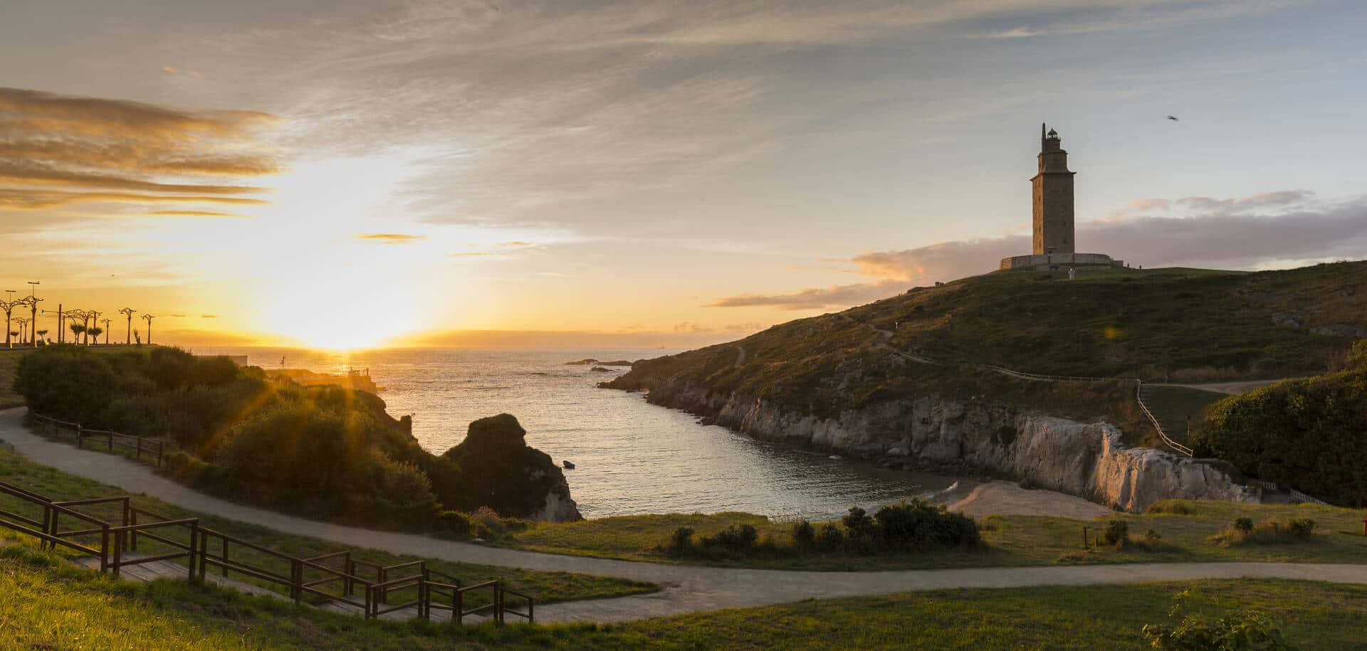 Tower Of Hercules Against The Sunset Sky Background